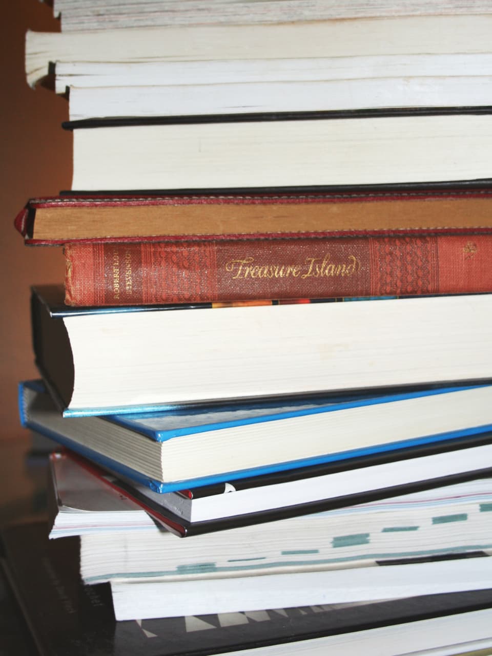 Rak perpustakaan yang penuh sesak dengan buku, sebagian bertumpuk di depan rak.